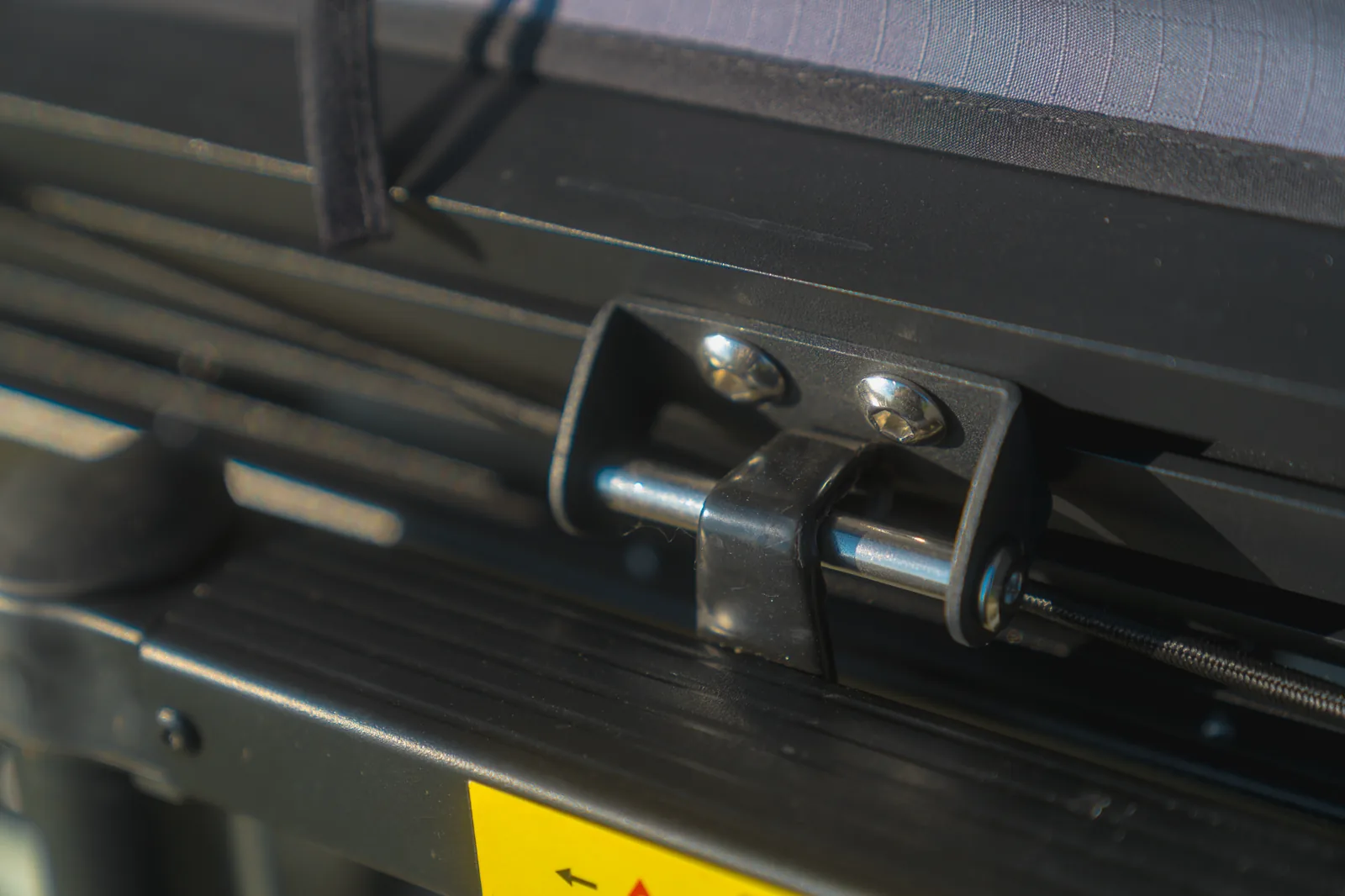 Close-up of a roof tent mounting bracket and bolts on a roof rack