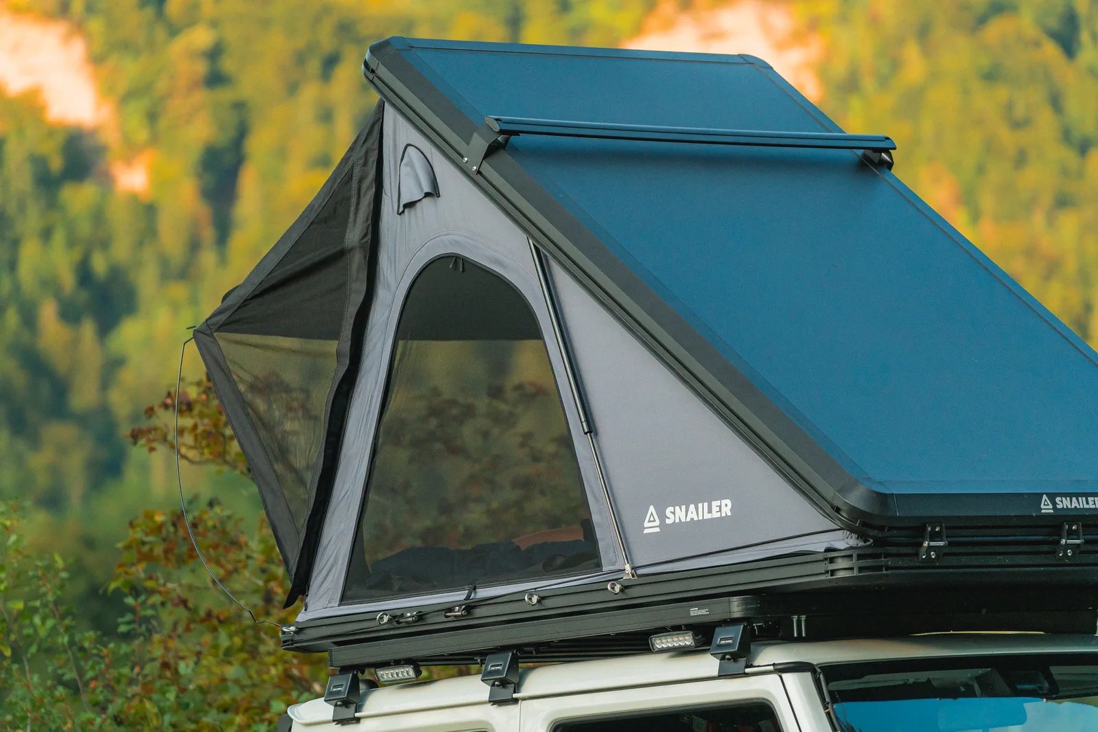 Otvoren tvrdi krovni šator SNAILER pokraj šume